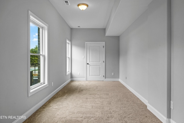 interior space with plenty of natural light and light colored carpet