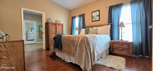 bedroom with connected bathroom, dark hardwood / wood-style flooring, and vaulted ceiling