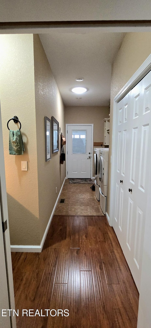 hall with dark wood-type flooring and independent washer and dryer