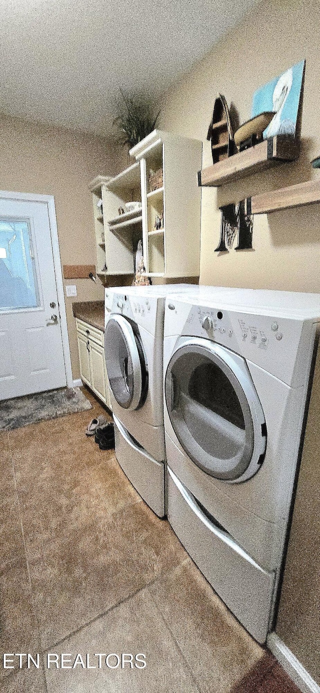 clothes washing area with washing machine and dryer and cabinets