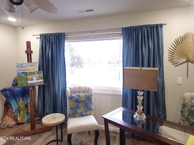 sitting room with hardwood / wood-style floors and ceiling fan