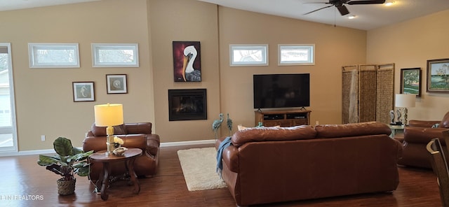 living room with a fireplace, lofted ceiling, ceiling fan, and dark wood-type flooring