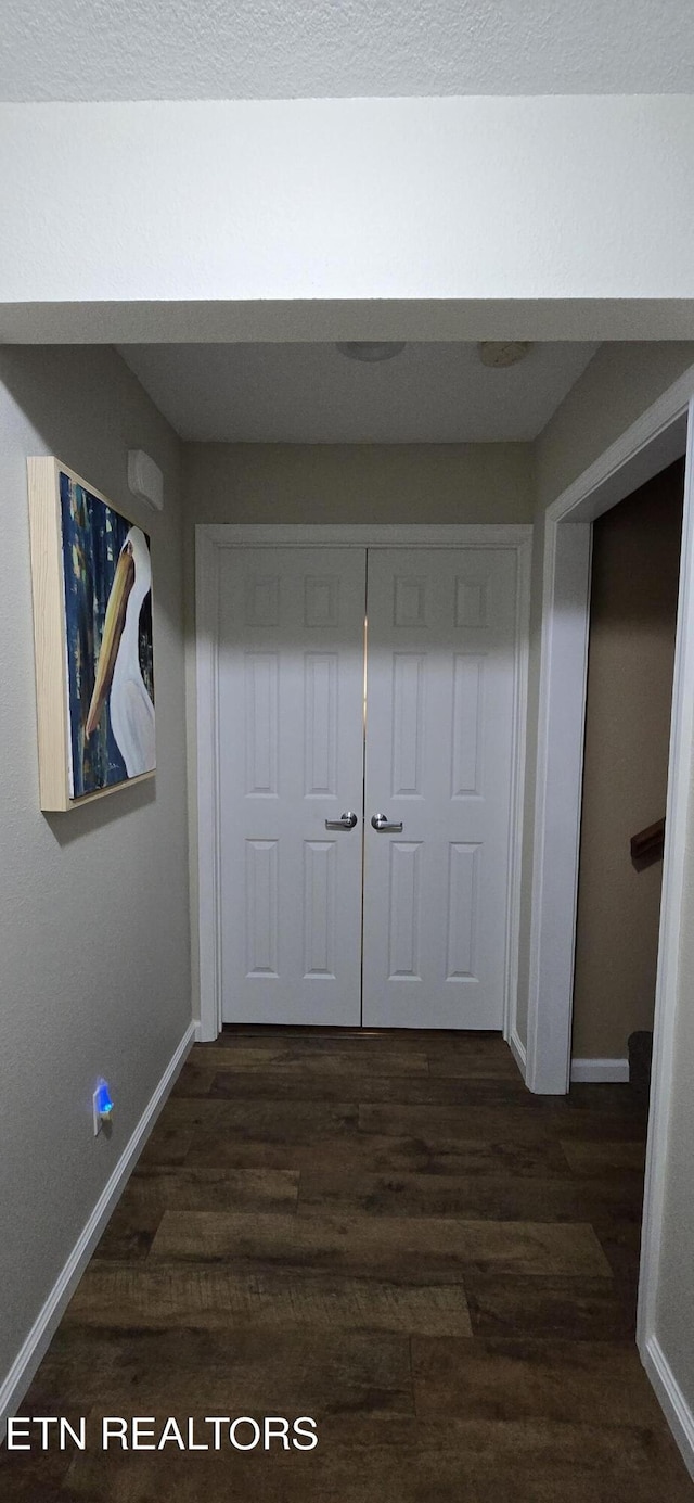 hallway with dark hardwood / wood-style flooring