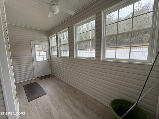 unfurnished sunroom with ceiling fan