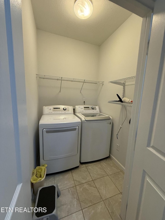 laundry area featuring light tile patterned flooring and washing machine and dryer