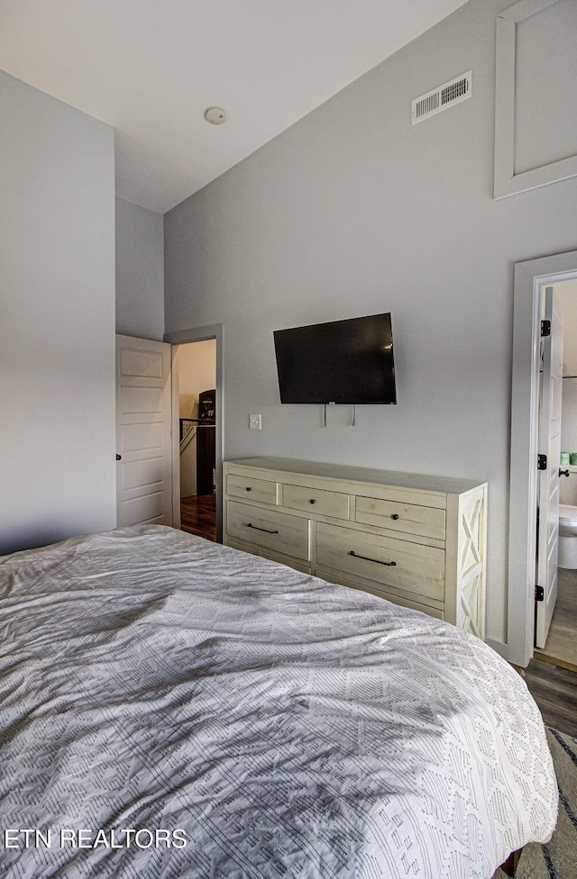 bedroom with a walk in closet, dark wood-type flooring, and connected bathroom