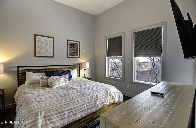 bedroom with dark hardwood / wood-style flooring