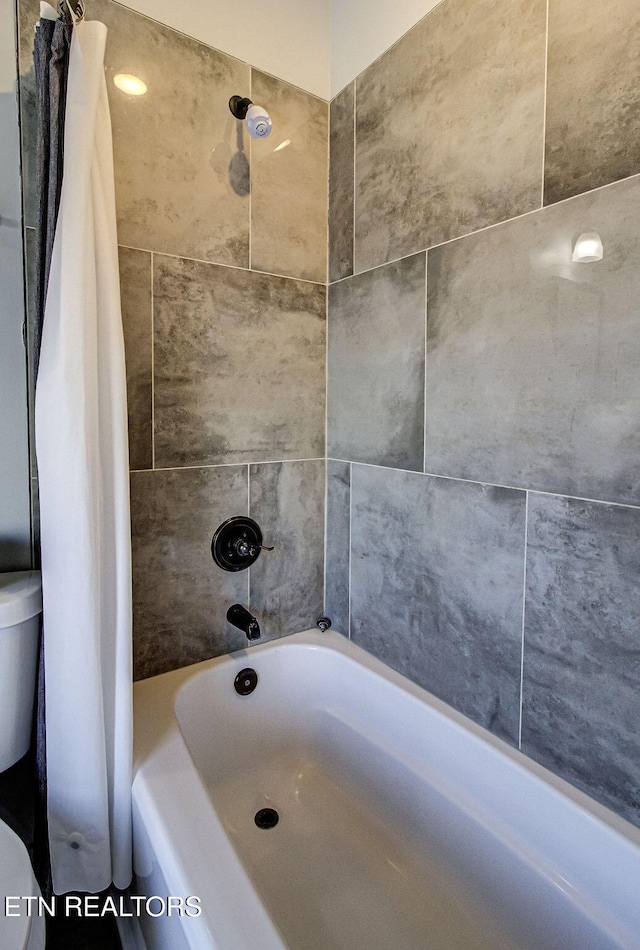 bathroom featuring shower / bath combination with curtain and toilet