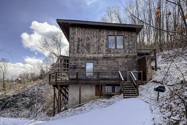 snow covered house with a deck