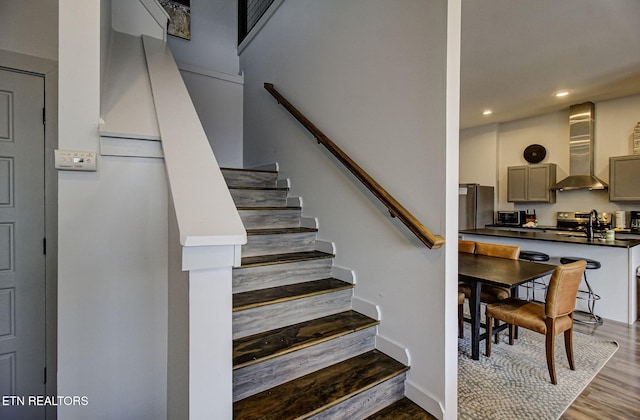 staircase with wood-type flooring and sink