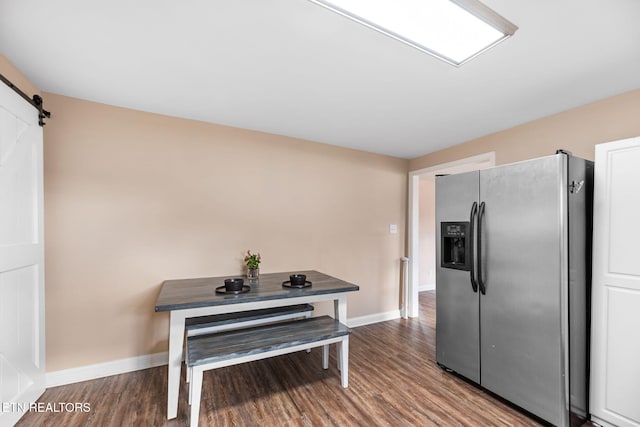 kitchen with stainless steel fridge with ice dispenser, wood-type flooring, and a barn door