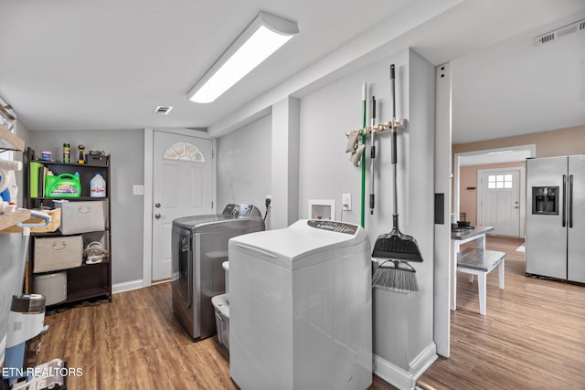 clothes washing area featuring washing machine and clothes dryer and hardwood / wood-style floors