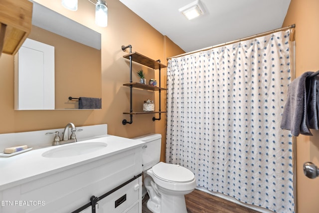 bathroom featuring wood-type flooring, walk in shower, vanity, and toilet