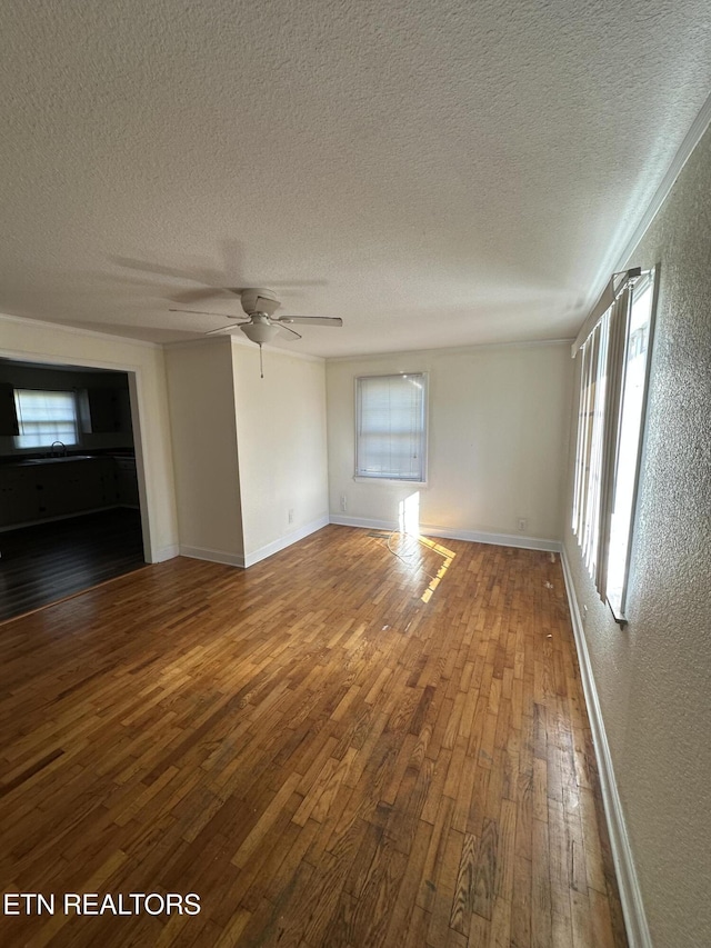 unfurnished living room with hardwood / wood-style floors, ceiling fan, and a textured ceiling