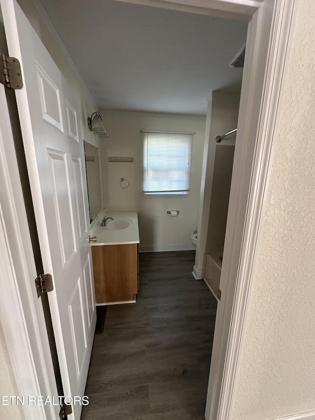 full bathroom featuring shower / bath combination, vanity, hardwood / wood-style flooring, and toilet