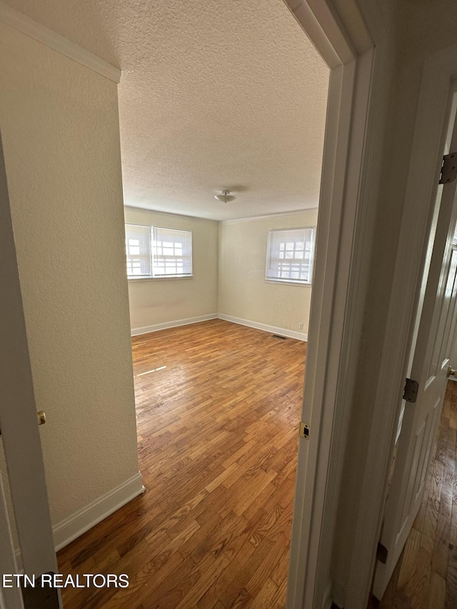 empty room featuring wood-type flooring and a textured ceiling