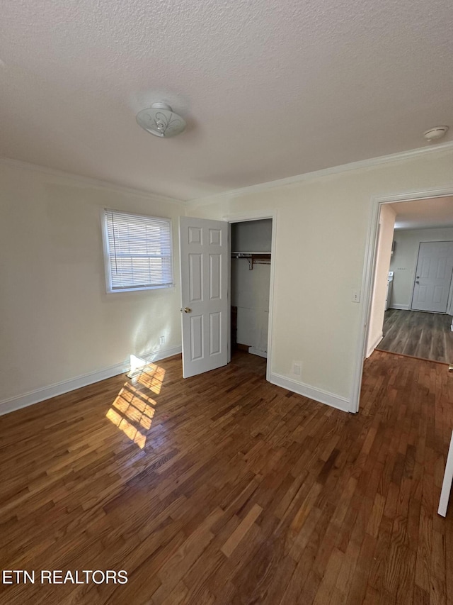 unfurnished bedroom with a textured ceiling, dark hardwood / wood-style floors, and a closet