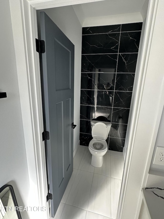 bathroom featuring tile walls, toilet, and tile patterned flooring