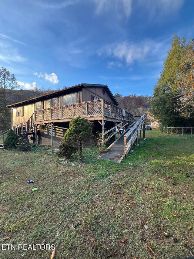 view of home's exterior featuring a deck and a yard