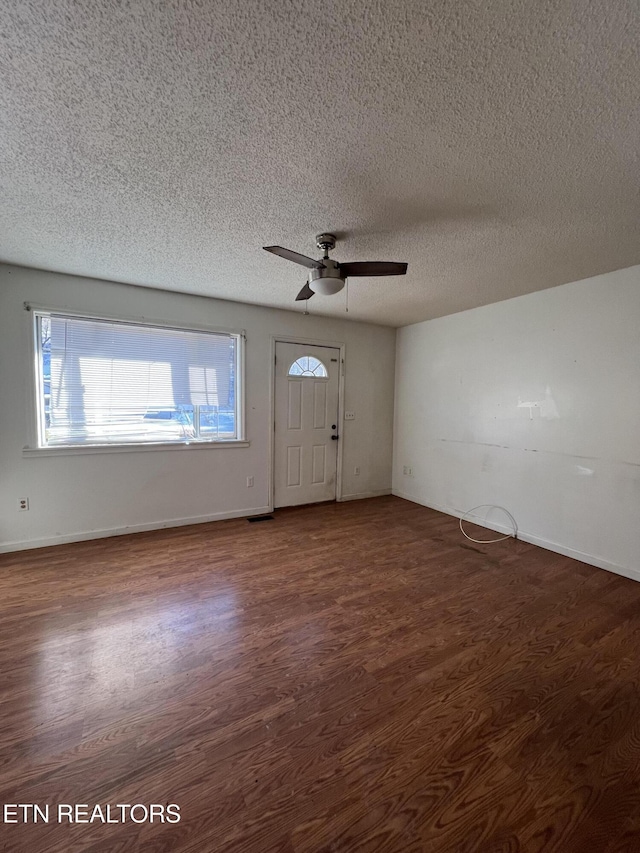 interior space with ceiling fan, dark wood finished floors, and baseboards