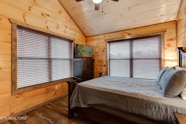 bedroom featuring lofted ceiling, wooden walls, hardwood / wood-style floors, and ceiling fan