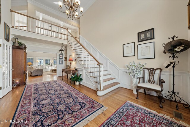 interior space with visible vents, stairway, a decorative wall, and ornamental molding