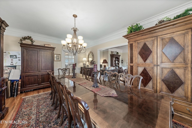 dining room featuring a chandelier, crown molding, and wood finished floors