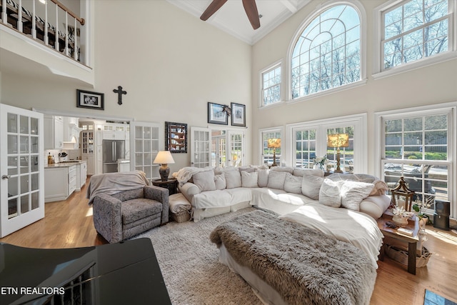 living room featuring french doors, light wood-style floors, ceiling fan, and ornamental molding