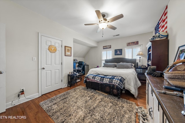 bedroom with wood finished floors, visible vents, baseboards, ceiling fan, and vaulted ceiling