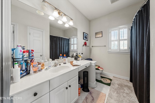 bathroom featuring vanity, tile patterned floors, toilet, and baseboards