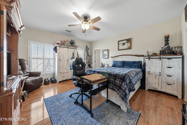 bedroom with visible vents, ceiling fan, and hardwood / wood-style floors