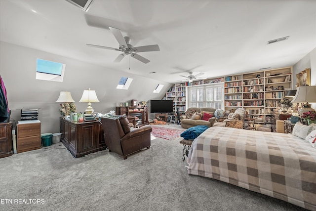 bedroom with visible vents, light carpet, a ceiling fan, and lofted ceiling with skylight