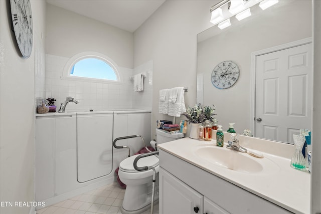 bathroom with tile patterned floors, toilet, a tub, and vanity