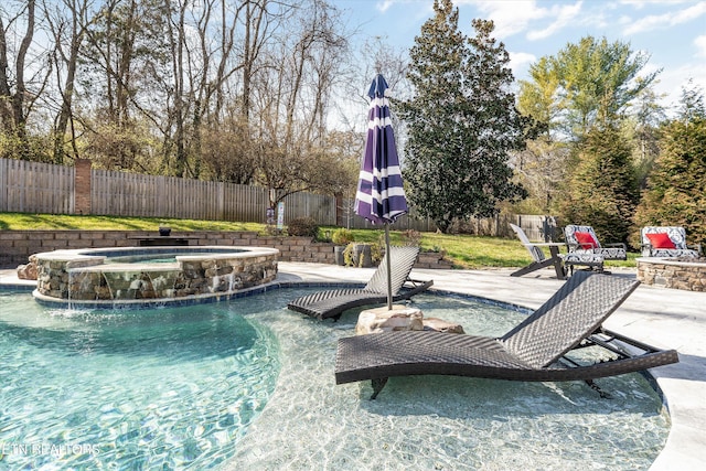 view of pool featuring a patio area, a pool with connected hot tub, an outdoor fire pit, and a fenced backyard