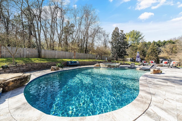 view of swimming pool with a pool with connected hot tub, a fenced backyard, and a patio area