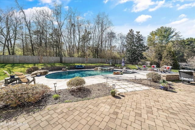 view of swimming pool with a patio area, a pool with connected hot tub, and a fenced backyard