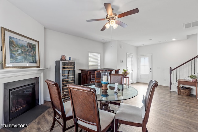 dining space featuring hardwood / wood-style floors, beverage cooler, and ceiling fan