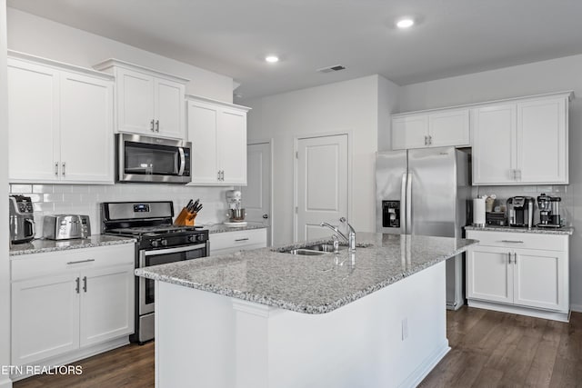 kitchen featuring sink, stainless steel appliances, white cabinets, and a center island with sink