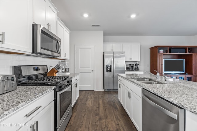 kitchen featuring sink, white cabinetry, stainless steel appliances, light stone countertops, and backsplash