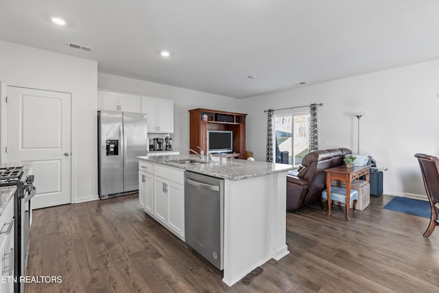 kitchen featuring sink, white cabinetry, light stone counters, a center island with sink, and stainless steel appliances