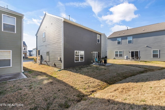 back of house featuring a lawn and a patio