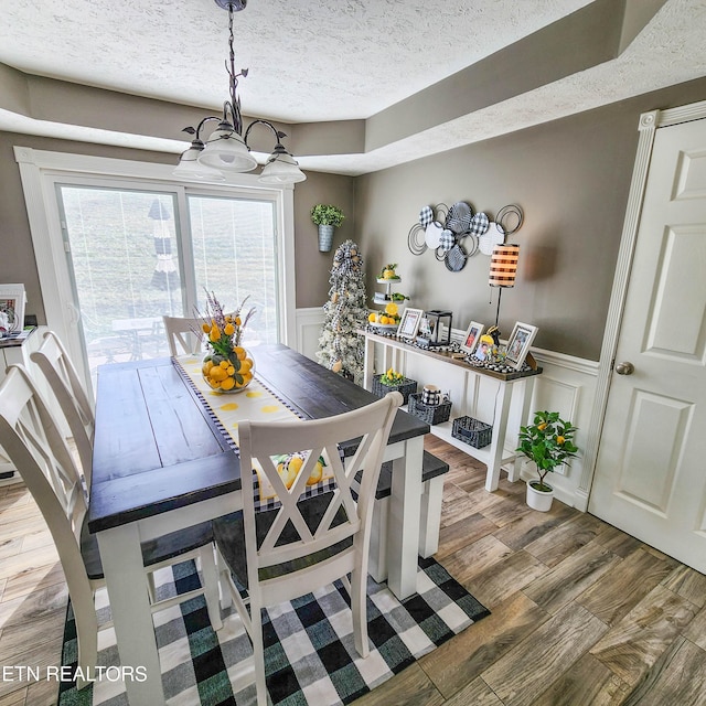 dining area featuring hardwood / wood-style flooring and a textured ceiling