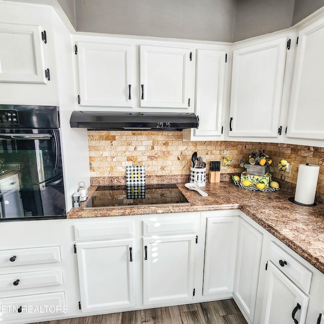 kitchen featuring white cabinets, backsplash, black appliances, light stone countertops, and dark wood-type flooring