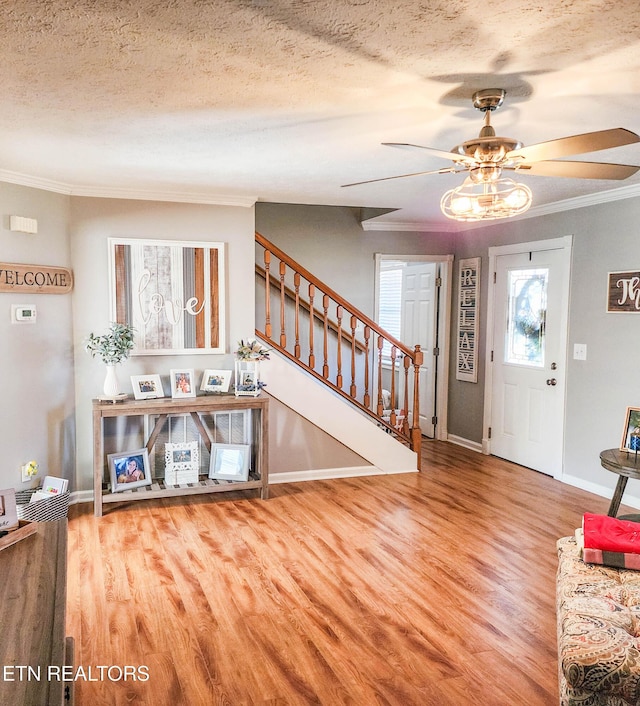 foyer featuring ceiling fan, crown molding, a textured ceiling, and hardwood / wood-style flooring