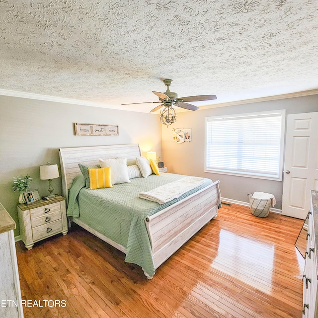 bedroom with ceiling fan, ornamental molding, hardwood / wood-style floors, and a textured ceiling