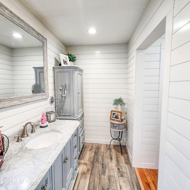 bathroom featuring vanity and wooden walls