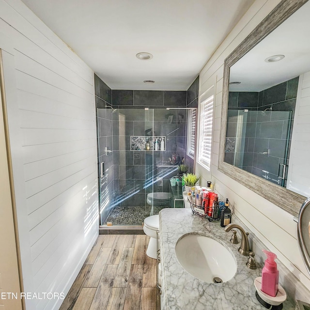 bathroom with vanity, a shower with door, and toilet