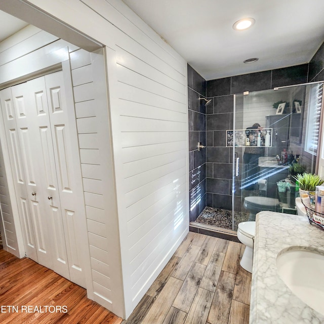 bathroom with vanity, tiled shower, and toilet