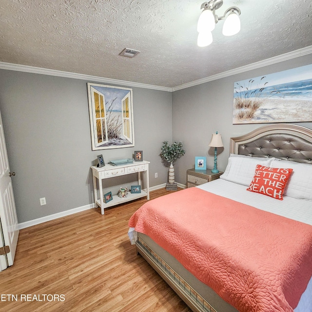 bedroom with hardwood / wood-style floors, crown molding, and a textured ceiling