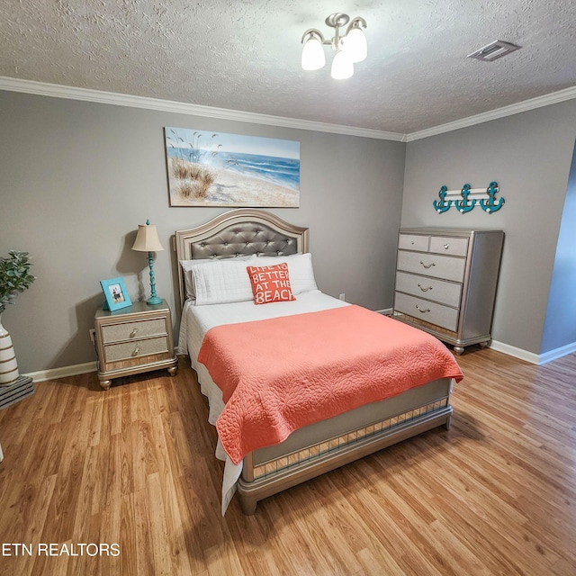 bedroom with crown molding, hardwood / wood-style floors, and a textured ceiling